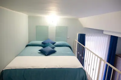 a bedroom with a bed with blue pillows on it at Pia Domus in Rome