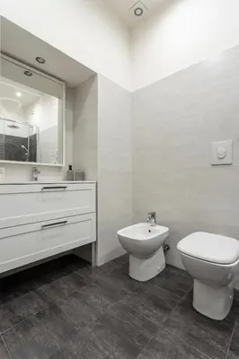 a bathroom with a toilet and a sink and a mirror at Pia Domus in Rome