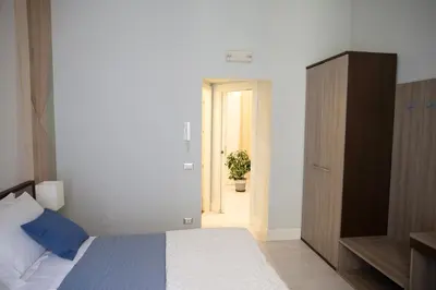 a bedroom with a bed and a cabinet and a plant at Pia Domus in Rome