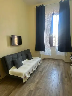 a couch sitting in a living room with blue curtains at Lin Mare in Rome