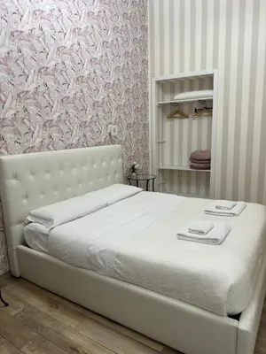 a bedroom with a white bed with a pink wallpaper at Lin Mare in Rome