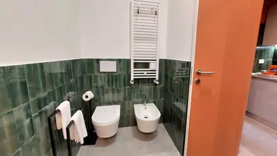a bathroom with a toilet and a sink and a urinal at Delmirani's Book Apartments - Vatican View in Rome