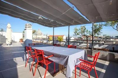 a table and chairs on a roof with a view at Delmirani's Book Apartments - Vatican View in Rome