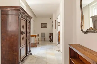 a hallway with a large wooden cabinet and a table at Bright Family 5BR Apartment in Parioli in Rome