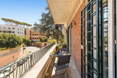 a balcony with a table and a view of a street at Bright Family 5BR Apartment in Parioli in Rome