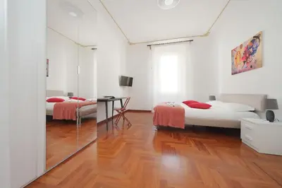 two beds in a white room with a mirror at 4BNB - St. Peters Dome Apartment in Rome