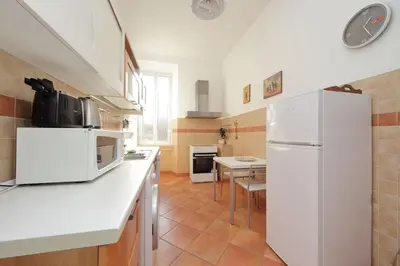 a kitchen with a white refrigerator and a table at 4BNB - St. Peters Dome Apartment in Rome