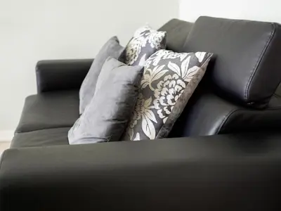 a black leather couch with pillows on it at Saint Peter Welcoming Apartment in Rome