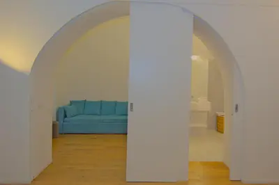 an archway with a blue couch in a living room at CasaBlanca Apartment in Rome