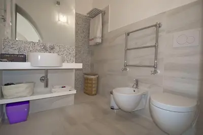 a white bathroom with a toilet and a sink at CasaBlanca Apartment in Rome