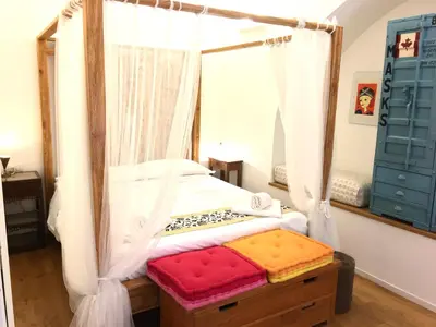 a bedroom with a canopy bed with a red cushion at CasaBlanca Apartment in Rome