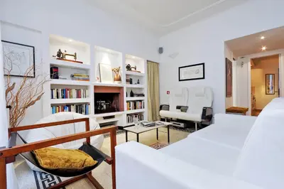 a living room with white furniture and bookshelves at Clementina in Rome