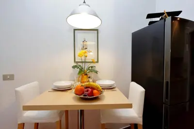 a table with a bowl of fruit and a black refrigerator at Clementina in Rome