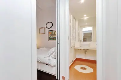 a small bedroom with a bed and a mirror at Clementina in Rome