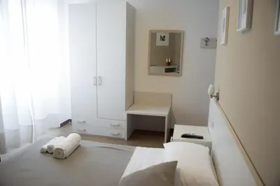 a white bedroom with a bed with towels on the floor at Anna Guest House in Rome