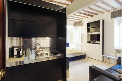 a kitchen with black cabinets and a sink in a room at Oro in Rome