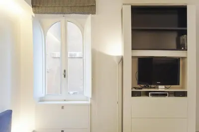a living room with a tv and a window at Oro in Rome