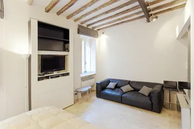 a living room with a black couch and a tv at Oro in Rome