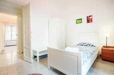 a white bedroom with a bed and a dresser at Palestrina in Rome