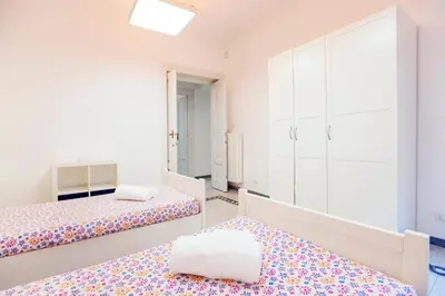 a white room with two beds and a closet at Palestrina in Rome