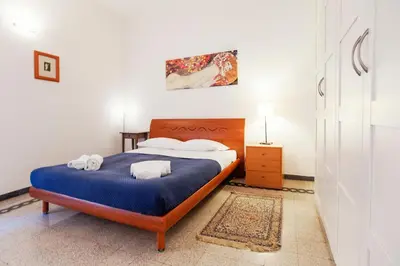 a bedroom with a bed with blue sheets and white pillows at Palestrina in Rome