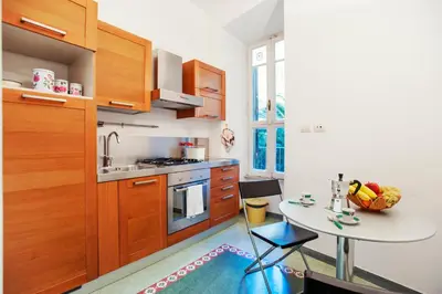 a kitchen with wooden cabinets and a table with a bowl of fruit at Palestrina in Rome