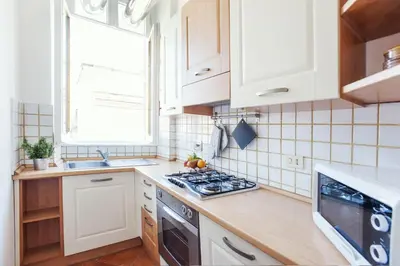 a kitchen with white cabinets and a stove top oven at Lungaretta3 in Rome