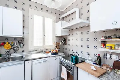a kitchen with white cabinets and blue stars on the wall at Otranto in Rome