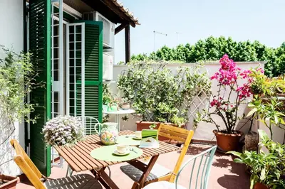 a patio with a table and chairs and flowers at Otranto in Rome