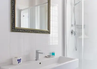 a white bathroom with a sink and a mirror at Otranto in Rome