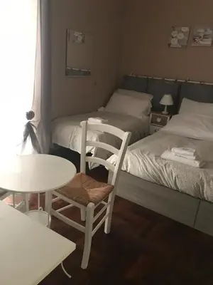 a room with two beds and a table and a chair at Morgagni House in Rome