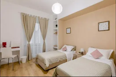a bedroom with two beds and a desk and a window at Charming 25 Apartment in Rome