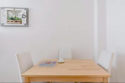 a wooden table with two chairs and a picture on the wall at Charming 25 Apartment in Rome