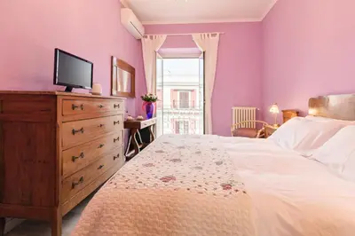 a bedroom with a bed and a dresser with a tv on it at A Roman Tale B&B in Rome