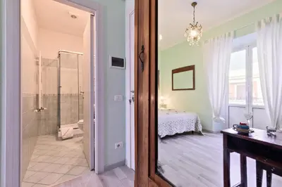 a bathroom with a glass door leading to a bedroom at A Roman Tale B&B in Rome