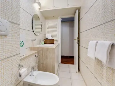 a white bathroom with a sink and a mirror at Folia Domus in Rome