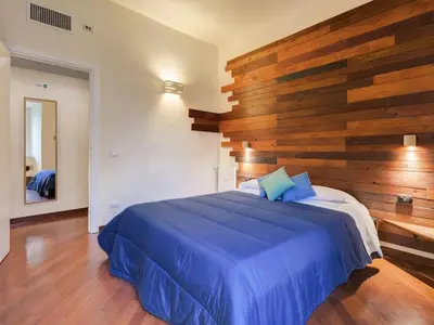 a bedroom with a blue bed with a wooden wall at Folia Domus in Rome
