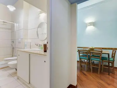 a bathroom with a toilet and a table with chairs at Folia Domus in Rome