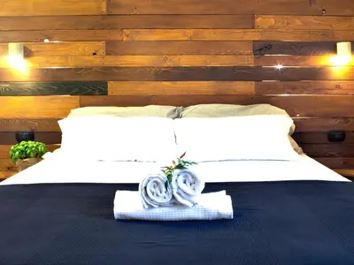 a bedroom with a bed with white sheets and wooden walls at Folia Domus in Rome