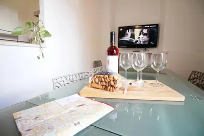a bottle of wine and two wine glasses on a table at Walk to the Colosseum from your Family Apt in Rome