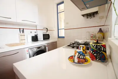 a kitchen with a stove and a white counter top at Walk to the Colosseum from your Family Apt in Rome