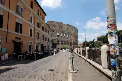 a street in a city with a group of people at Walk to the Colosseum from your Family Apt in Rome