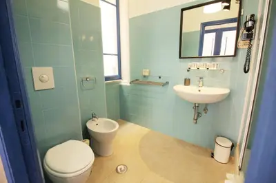 a bathroom with a toilet and a sink at Walk to the Colosseum from your Family Apt in Rome