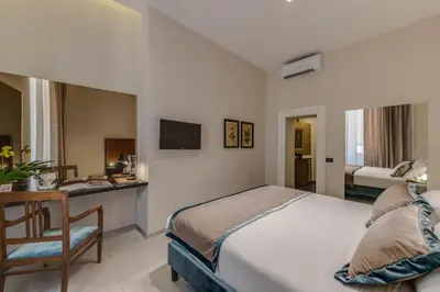 a bedroom with a bed and a desk with a chair at Navona Theatre Hotel in Rome