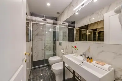 a white bathroom with a toilet and a sink at Navona Theatre Hotel in Rome