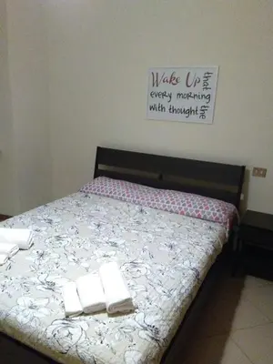 a bed with towels on it with a sign on the wall at FamilyBed Roma Monteverde-Vaticano in Rome
