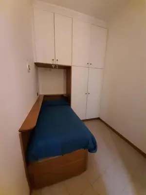 a small room with a bed and white cabinets at FamilyBed Roma Monteverde-Vaticano in Rome
