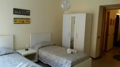a bedroom with two beds and a mirror at FamilyBed Roma Monteverde-Vaticano in Rome