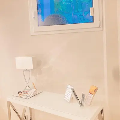 a white table with a lamp and a picture on the wall at Tama Rooms in Rome