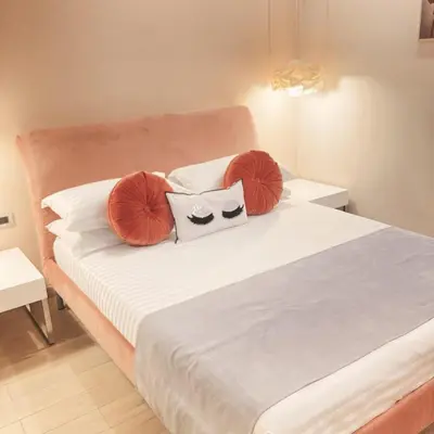 a bed with orange and white pillows on it at Tama Rooms in Rome